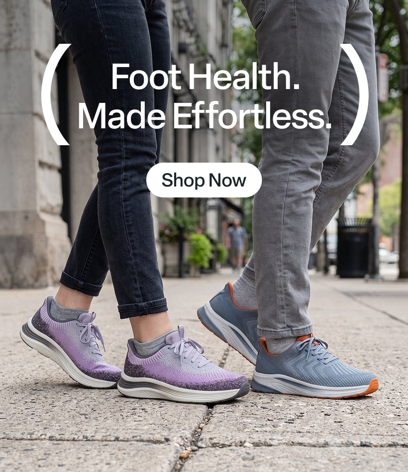 Two people walking on a city sidewalk wearing Women's Nira - Gray/Plum (SKU:80090, left) & Men's Tilos Hands-Free - Blue/Orange (SKU:20024, right) sneakers. 