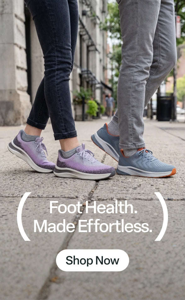 Two people walking on a city sidewalk wearing Women's Nira - Gray/Plum (SKU:80090, left) & Men's Tilos Hands-Free - Blue/Orange (SKU:20024, right) sneakers. 